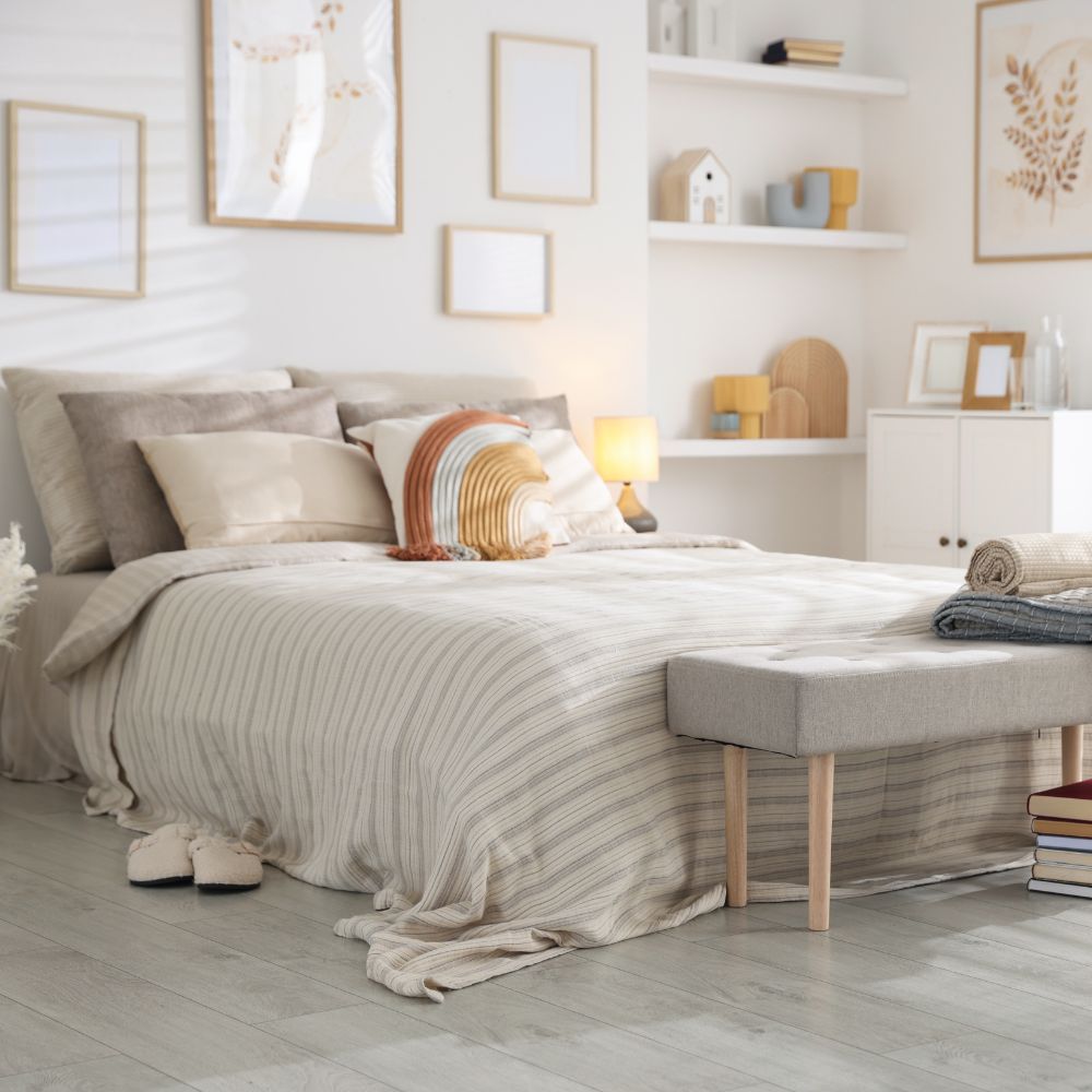 Neatly made bed in a bedroom with light decor